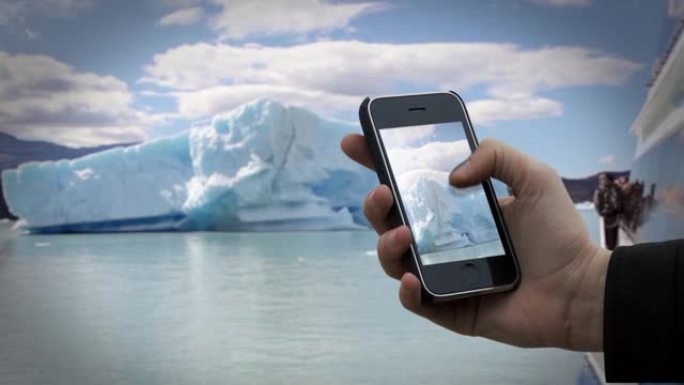 在佩里托莫雷诺冰川冰山附近的一艘旅游船上，男性双手拿着一台旧智能手机。