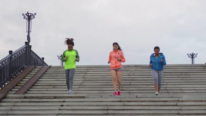 三个女性同伴在城市一起奔跑