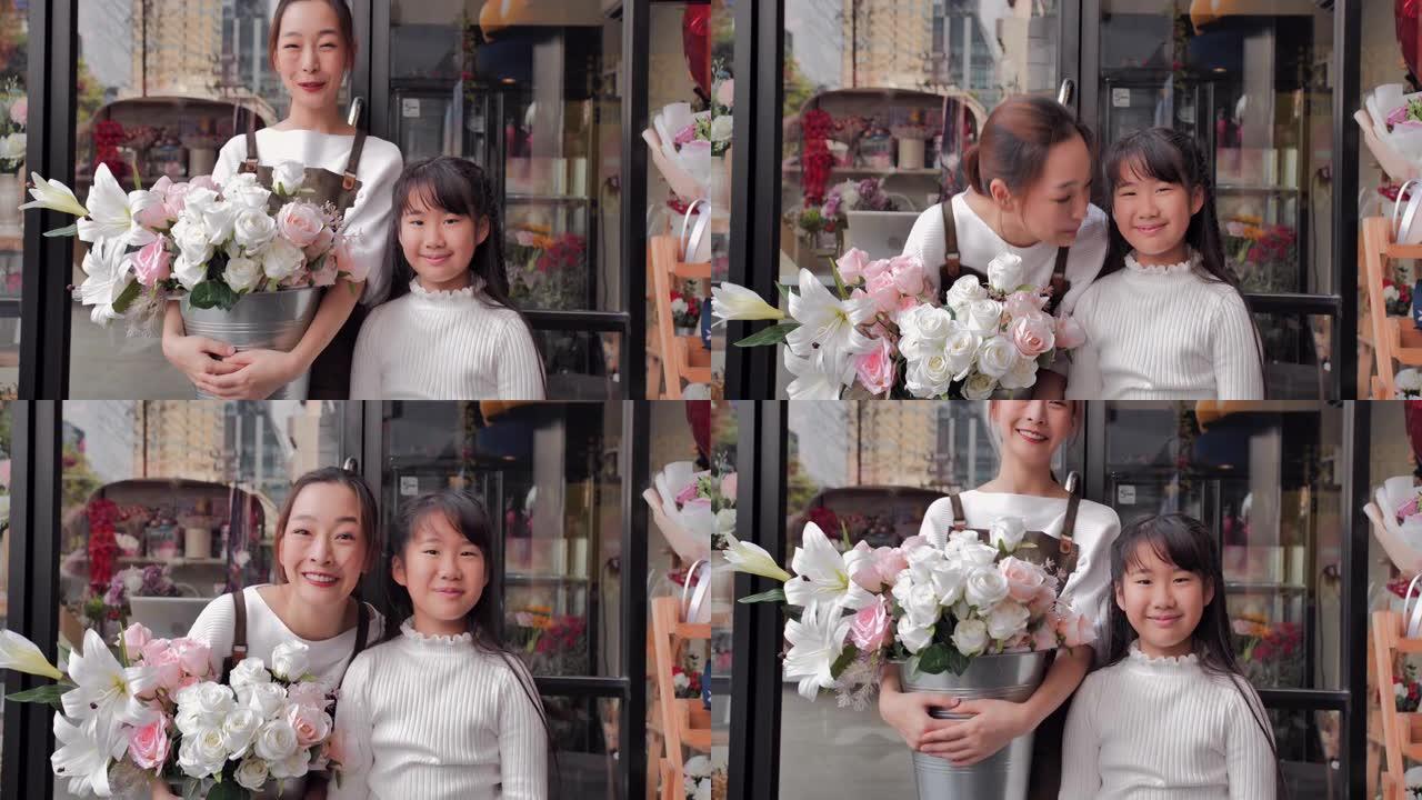 这是一幅亚洲年轻母亲和10岁女儿的肖像，花店老板站在关门后和新冠肺炎疫情发生后开门的花店前看着相机。