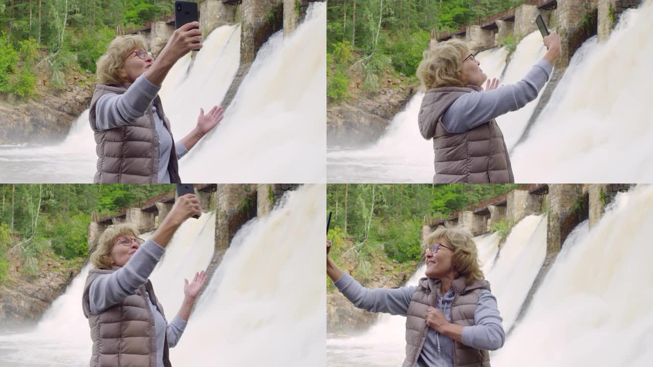 高级妇女在溢洪道前进行视频通话