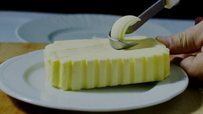 用小刀在白盘上搅打黄油的超慢动作微距 (特写)