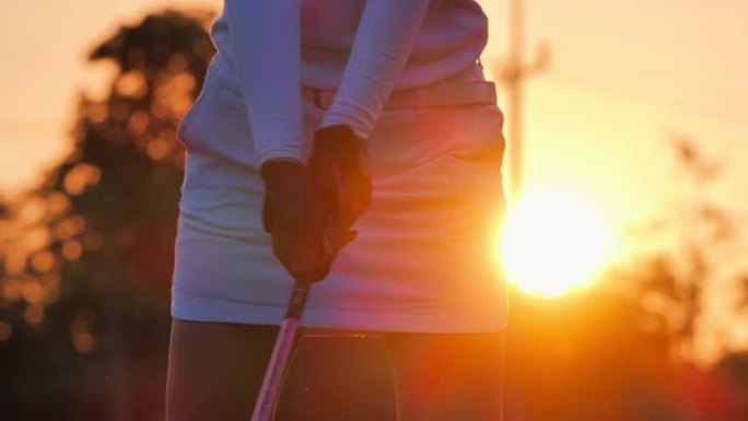 高尔夫球手的剪影妇女在夏天扫荡并保持高尔夫球场以放松身心。日落时的剪影高尔夫球手。体育电影。自信，力