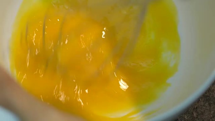 用手动搅拌器搅拌鸡蛋。