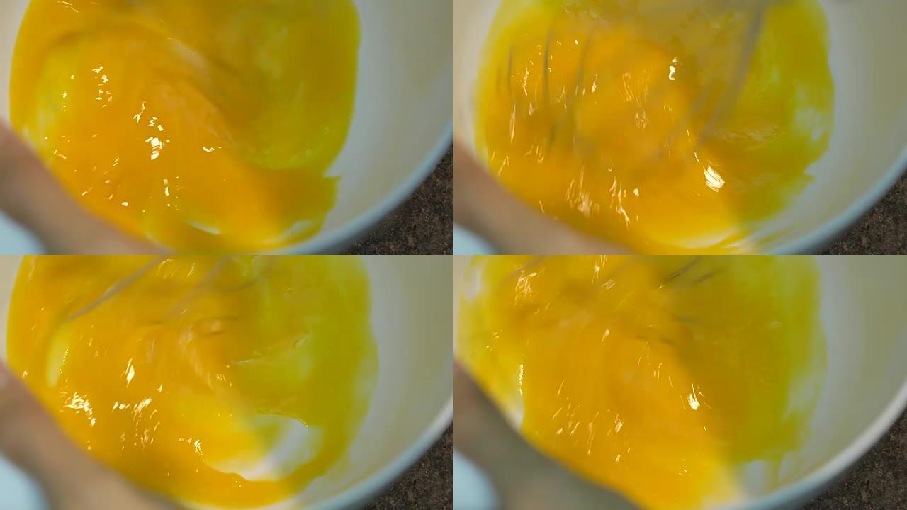 用手动搅拌器搅拌鸡蛋。