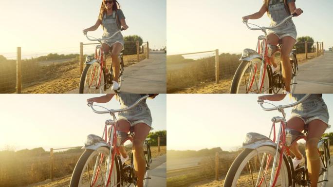快乐的女孩在日落时分骑着沙滩巡洋舰自行车