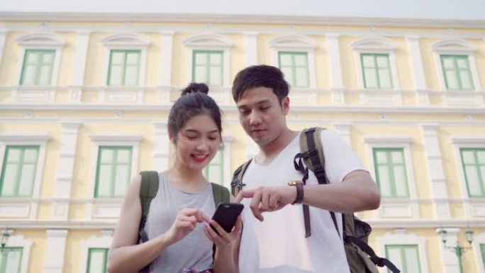 旅行者亚洲夫妇在泰国曼谷的位置图上的方向，夫妇在度假旅行时使用手机在地图上寻找地标。生活方式夫妇在城