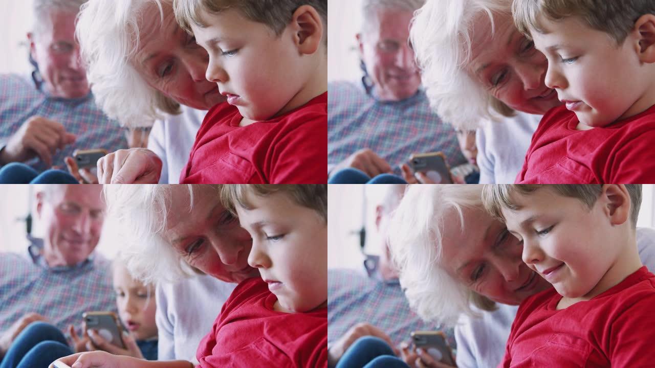爷爷奶奶在家用手机和孙子玩电子游戏