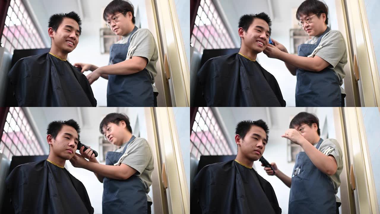 由于旅行禁令，一名亚洲华裔中年妇女正在厨房为儿子剪头发和修剪头发