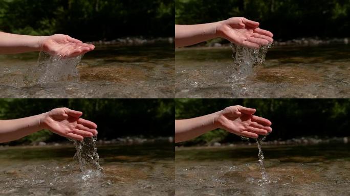 慢动作: 不知名的女孩从宁静的小溪中挖出少量水。