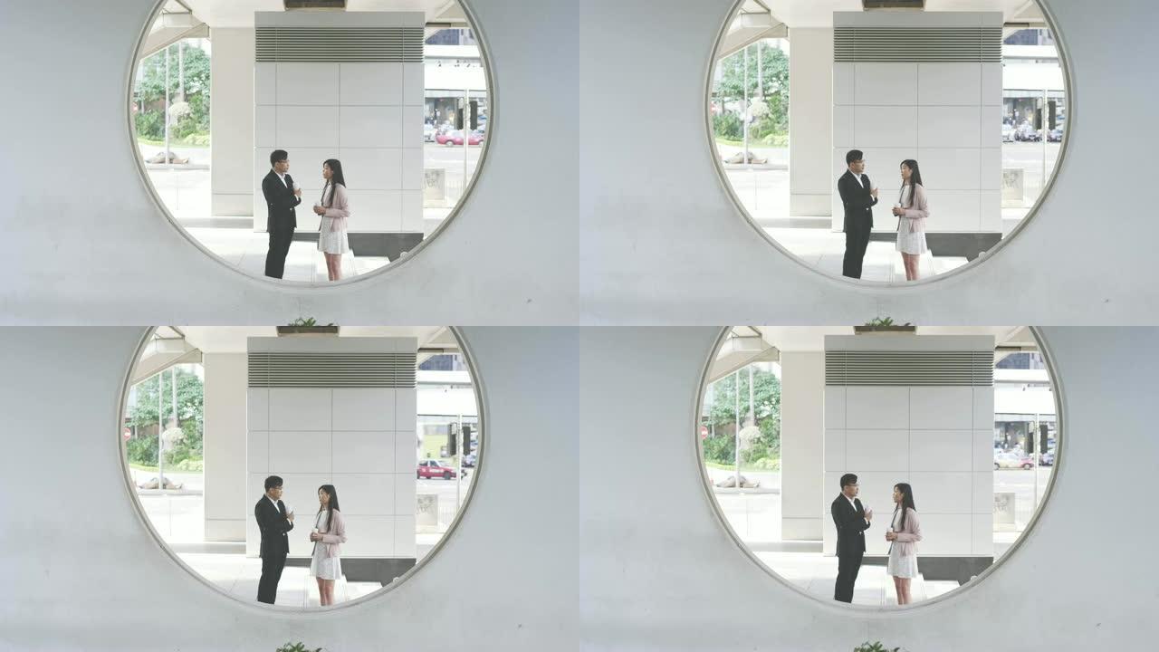 两名中国商人在户外的圆形结构后面交谈