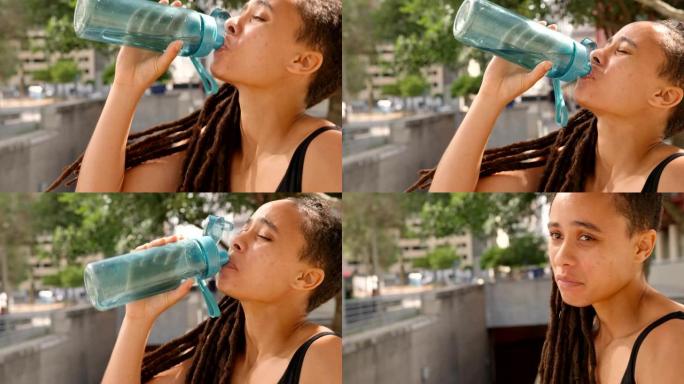 城市4k中年轻的非洲裔美国妇女饮用水的侧视图