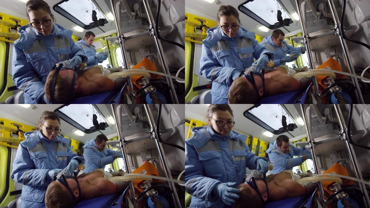护理人员在救护车上给男子戴上氧气面罩