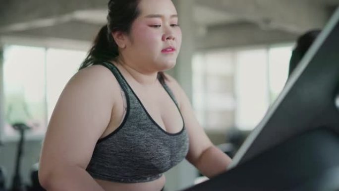 超重妇女在健身房跑步跑步机有氧运动锻炼。
