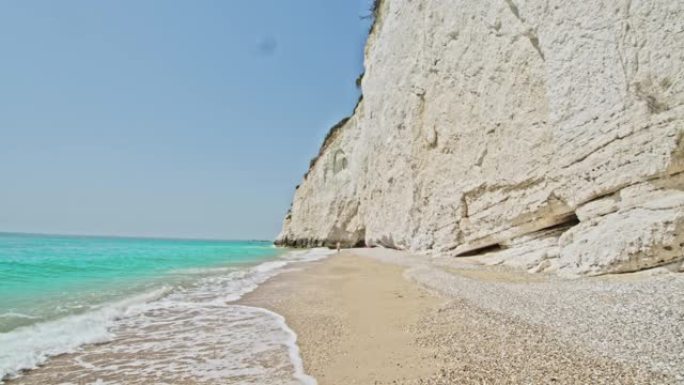 意大利普利亚阳光明媚的绿松石海滩上方的白色悬崖