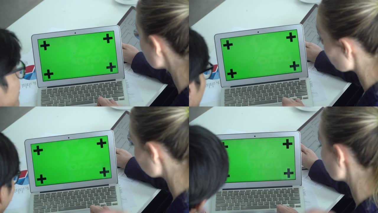 两个人使用带色度键的笔记本电脑