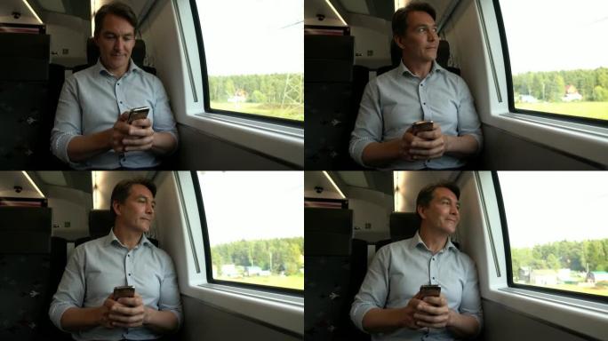 英俊的男人在火车上通勤，用智能手机发短信，然后看着风景