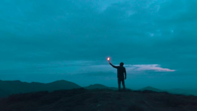 站在夜山上的男性火把群山