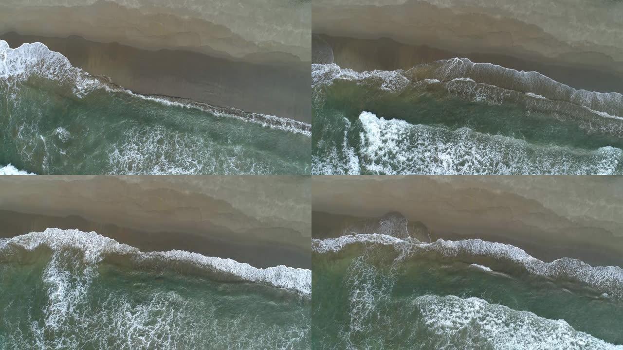 在沙质baech上空中俯下拍摄海浪。