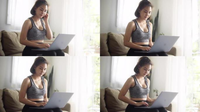 年轻女子在家用笔记本电脑做瑜伽锻炼