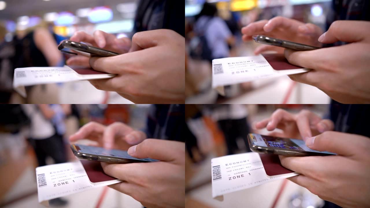 CU男子的手握着登机牌，护照和智能手机，并带有机场柜台检查背景