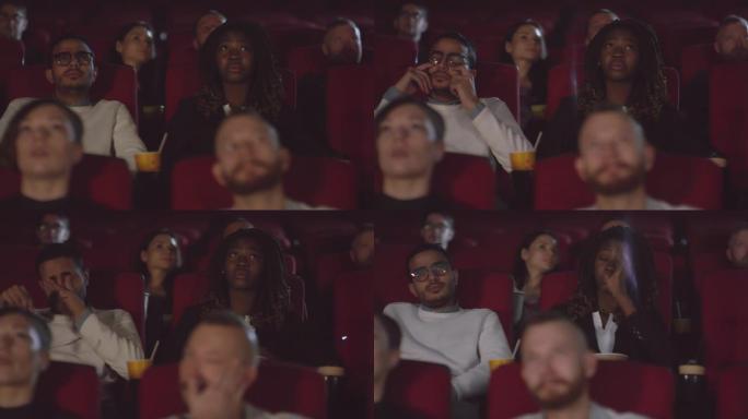 男人和女人在电影院看电影时哭泣