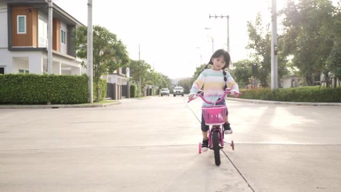 在阳光明媚的公园里骑自行车的女孩