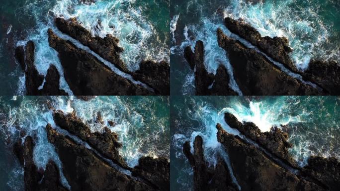 俯视海浪在岩石海岸线上撞击的抽象鸟瞰图