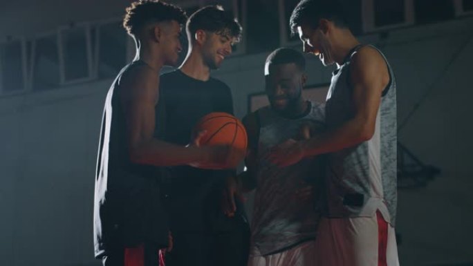 年轻职业男球员的电影慢动作镜头在开始在健身房练习篮球锻炼之前一起玩得很开心