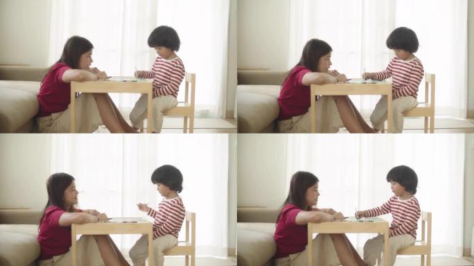 亚洲男孩早上跟妈妈做作业