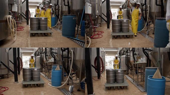 拉丁美洲操作员在一家啤酒厂拉着带有4个啤酒桶的手动叉车