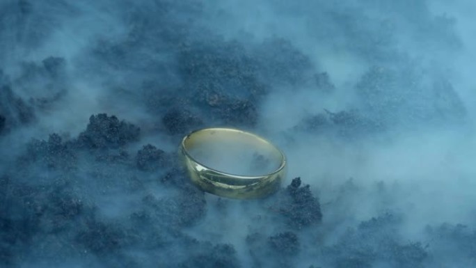 在烟熏的幻想景观中拾起的金戒指