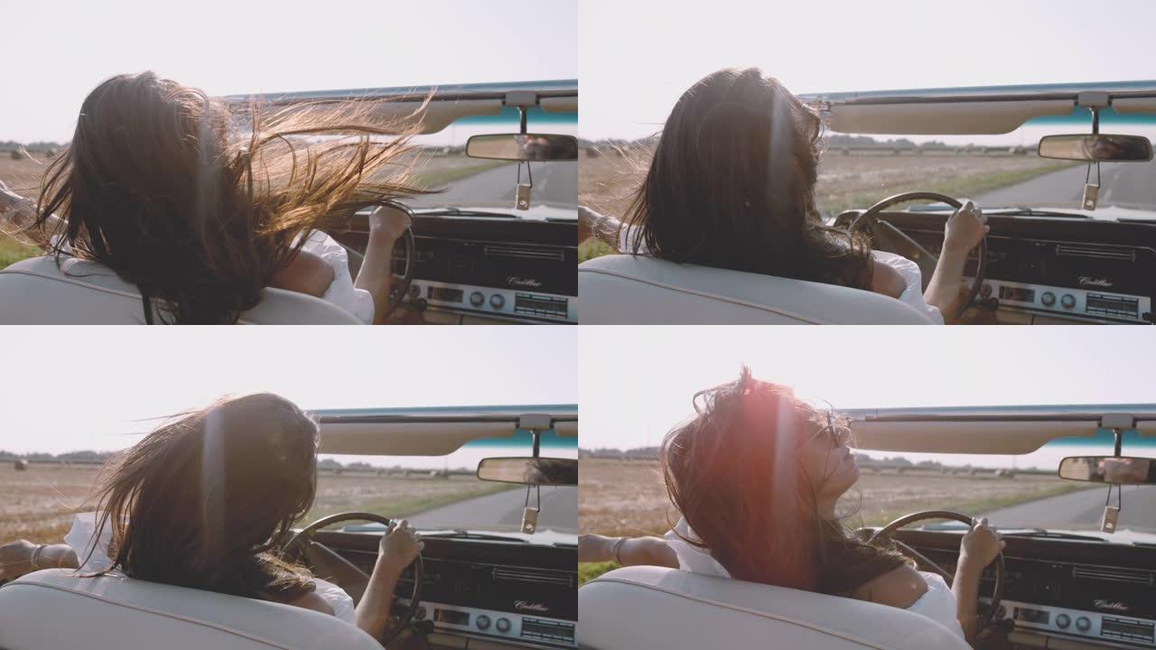 SLO MO女士无忧无虑的年轻女子沿着阳光明媚的乡村田野驾驶敞篷车