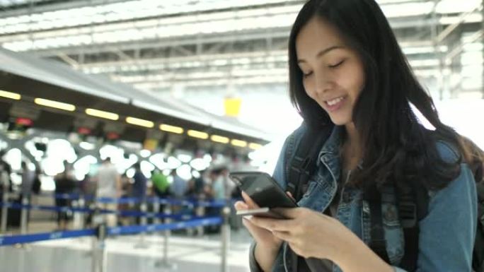 亚洲旅游妇女在机场航站楼使用电话
