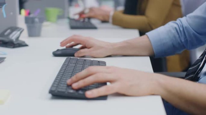 在现代办公室: 商人坐在他的台式计算机旁工作，项目经理和女团队负责人站在他旁边。他们进行讨论，找到问