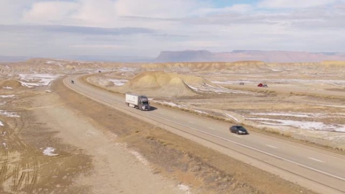 空中: 半拖车在犹他州风景秀丽的高速公路上上下行驶。