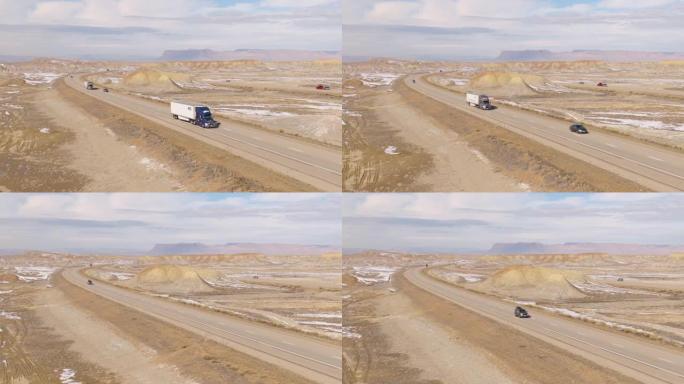 空中: 半拖车在犹他州风景秀丽的高速公路上上下行驶。