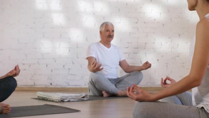 瑜伽教练和客户夫妇交叉双腿坐着放松