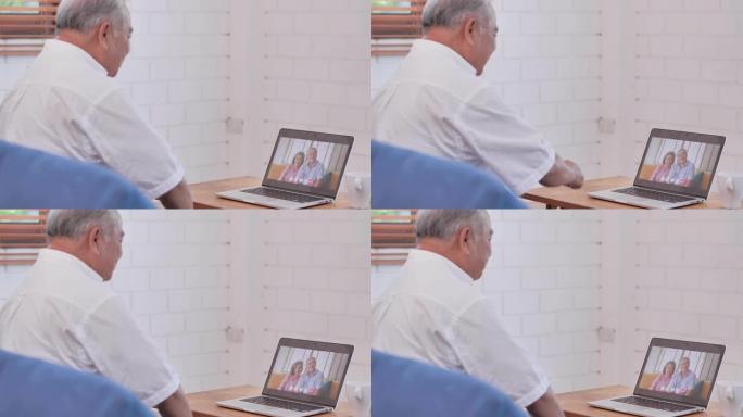 在使用计算机和视频会议技术进行社交距离期间，亚洲老年祖父在视频会议上与国外的亚洲夫妇在家中进行视频通