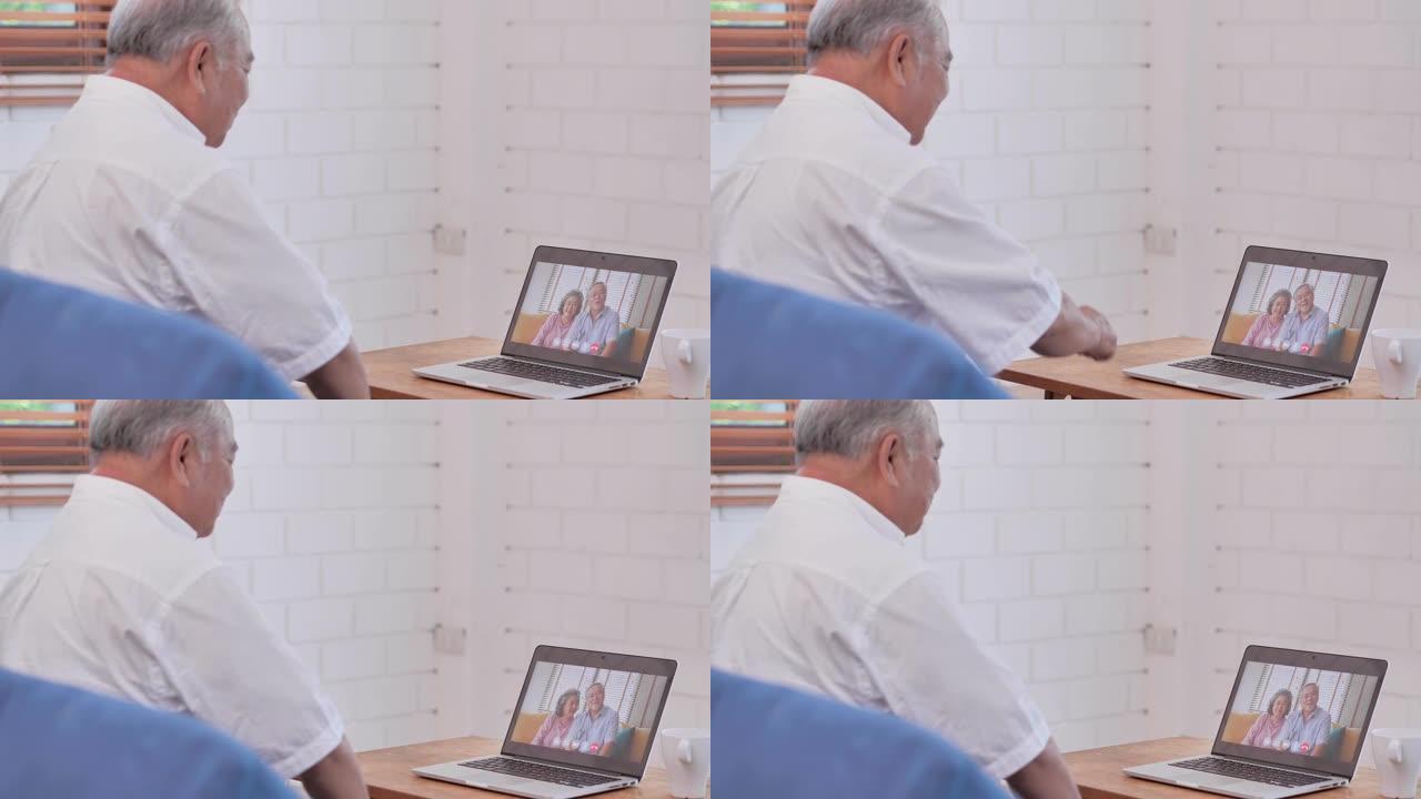 在使用计算机和视频会议技术进行社交距离期间，亚洲老年祖父在视频会议上与国外的亚洲夫妇在家中进行视频通