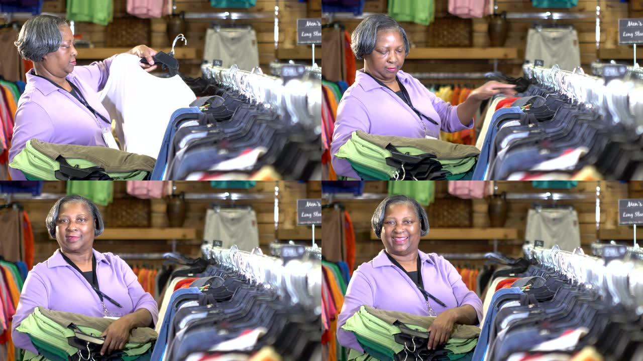 在商店工作的高级妇女，将衣服挂在架子上