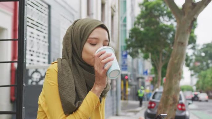 戴头巾的女人喝外卖咖啡