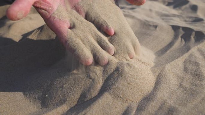 男人手中的沙子。慢动作。