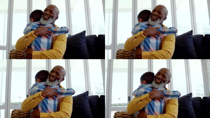 成熟的黑人父亲在舒适的家庭4k客厅拥抱儿子的前视图