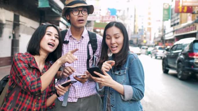 三个快乐的年轻朋友游客在智能手机上阅读地图指南
