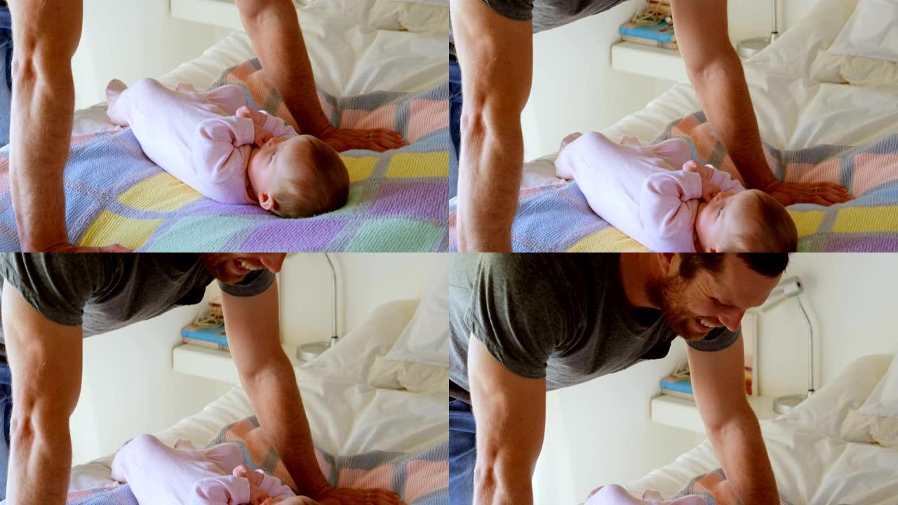 中年白人父亲靠在床上和婴儿在舒适的家庭4k玩耍的侧视图