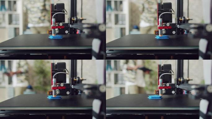 3D打印机制作塑料制品的特写镜头，人在背景中行走