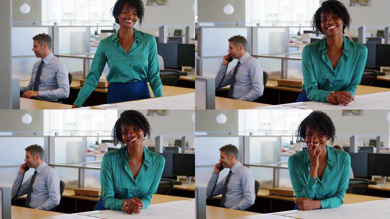 年轻微笑的黑人女商人在办公室走向相机