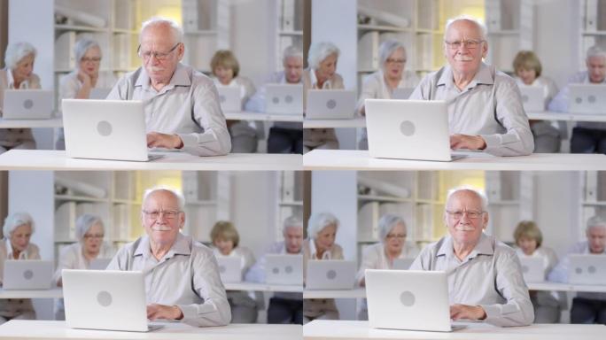 开朗的老人在计算机课上摆姿势