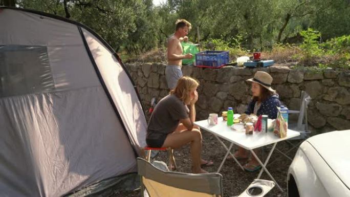 女士家庭放松，在阳光明媚的夏季露营地用餐