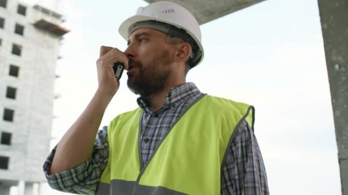 建筑工人在建筑工地用对讲机说话